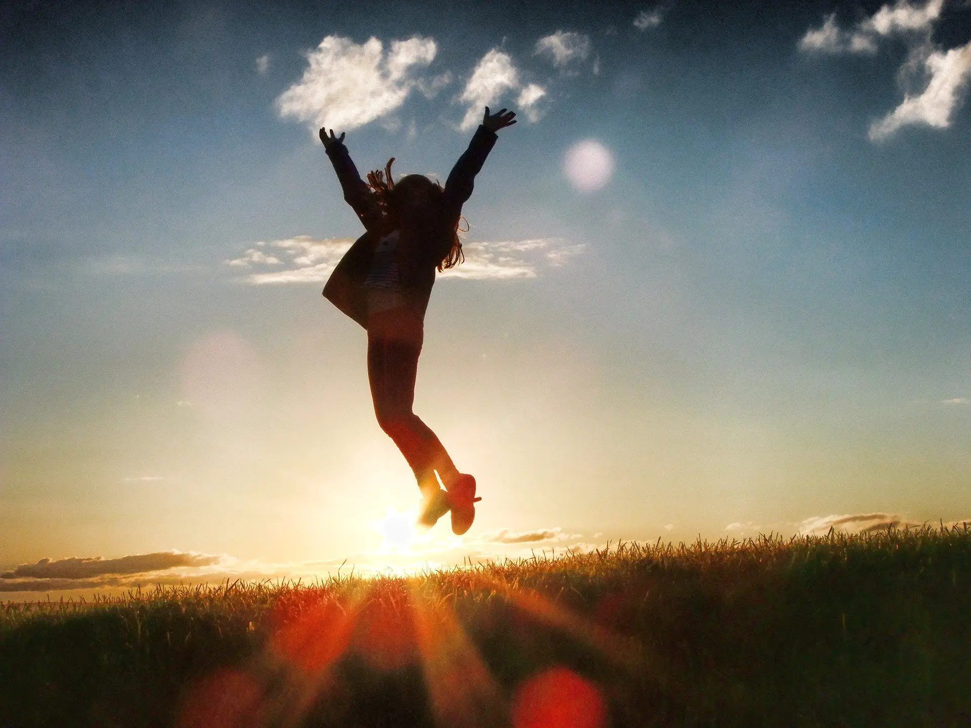 A woman jumping for joy during the sunset.