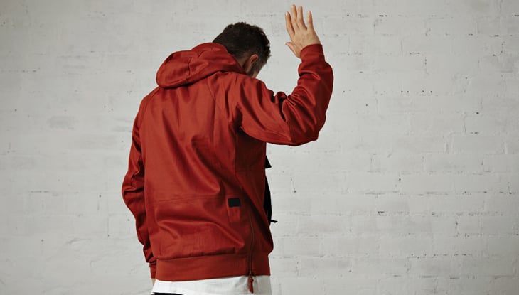 young man in red jacket shows us his back and waves goodbye